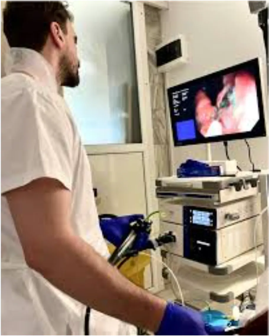Medic gastroenterolog efectuând o colonoscopie de precizie în sala de endoscopie a Clinicii Sfântul Luca Bacău, cu monitor pentru fotodocumentare